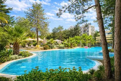 a swimming pool at a resort with palm trees at Harmony Suites Grand Resort-15 Private Apartment in Sunny Beach
