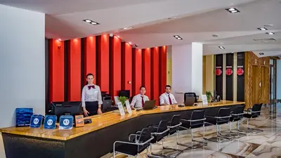 three men are standing at a long desk in a room with chairs at Premier Fort Beach Aparthotel - Sunny Beach in Sveti Vlas