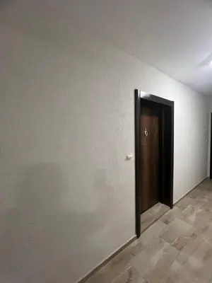 a wall with a door in a room with a tile floor at Izgrev View apartment bs in Burgas City