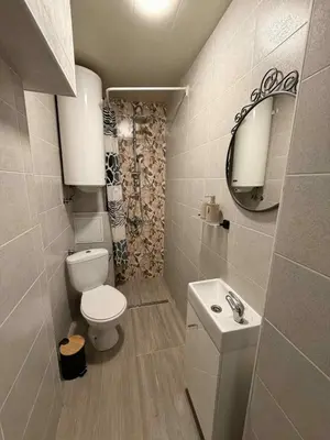 a bathroom with a toilet and a sink and a mirror at Dimitrov cathedral apartament in Varna City