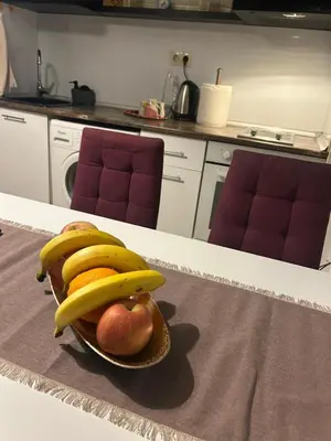 a bowl of fruit with bananas and apples on a table at Dimitrov cathedral apartament in Varna City