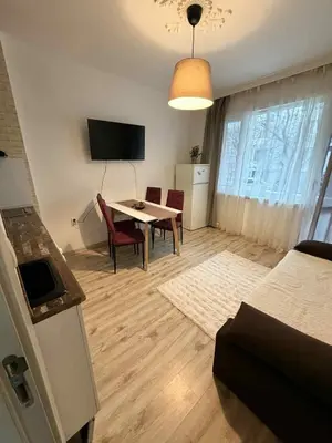 a living room with a table and chairs and a television at Dimitrov cathedral apartament in Varna City