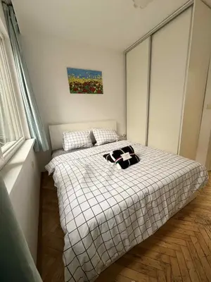a bedroom with a bed in a room with a window at Dimitrov cathedral apartament in Varna City