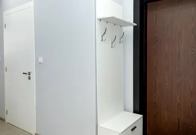 a white room with a wooden door and a closet at Stylish 2BR Apartment with Underground Parking, Varna by Flat Manаger in Varna City