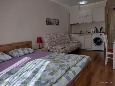 a bedroom with a bed and a couch and a kitchen at Marvel Deluxe in Sunny Beach