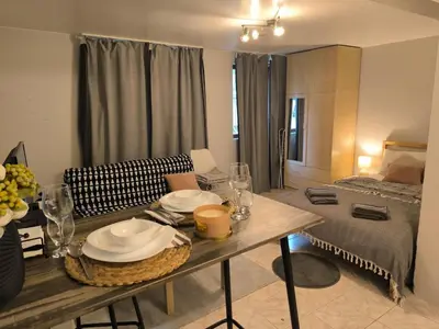 a living room with a table and a bed at Top Center Apartment in Varna City