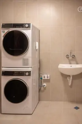 a washer and dryer in a bathroom with a sink at Леглото in Topoli