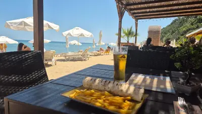 a table with a plate of food and a drink on the beach at Breathtaking sea view in Byala