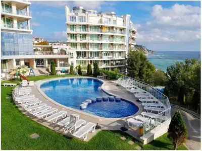 a swimming pool with lounge chairs and a large building at Breathtaking sea view in Byala