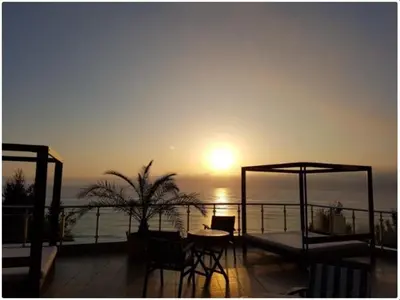 a sunset on a balcony with a table and chairs at Breathtaking sea view in Byala