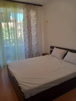 a bedroom with a large bed and a window at Слънчев бряг Sunny day 6 One bedroom apartment in Sunny Beach