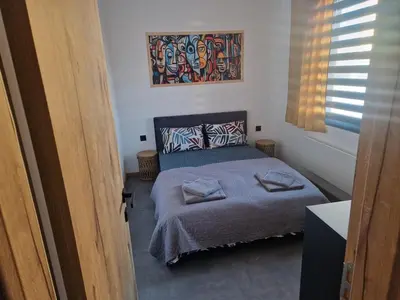 a bedroom with a bed and a painting on the wall at Family House Burgas in Burgas City