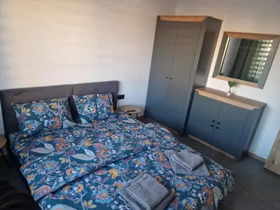 a bedroom with a bed with a blanket and a mirror at Family House Burgas in Burgas City