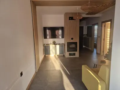 a living room with a yellow couch and a television at Family House Burgas in Burgas City