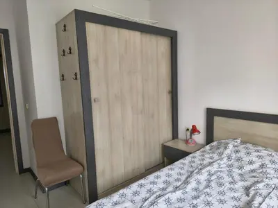 a bedroom with a bed and a chair and a closet at Sunny sea apartment - 100 meters from the sea in Chernomorets
