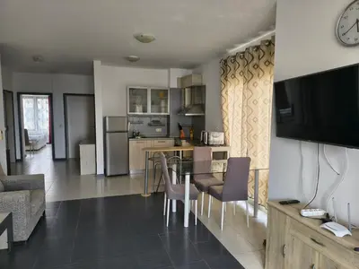 a kitchen and living room with a table and chairs at Sunny sea apartment - 100 meters from the sea in Chernomorets