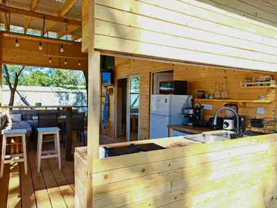 a kitchen and dining area of a wooden cabin at Бунгало Лимонада in Chernomorets