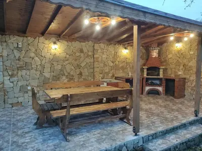 a patio with a wooden bench and a fireplace at При Приятели in Nesebar