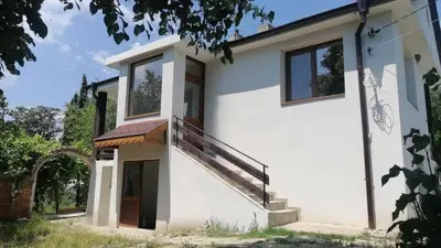 a white house with a staircase on the side of it at При Приятели in Nesebar