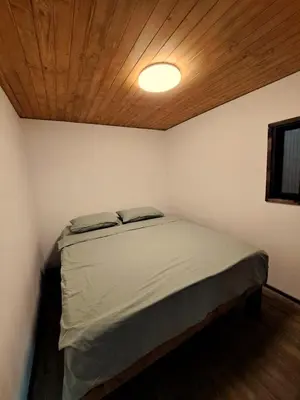 a bedroom with a bed with a wooden ceiling at Бунгало Борче in Burgas City