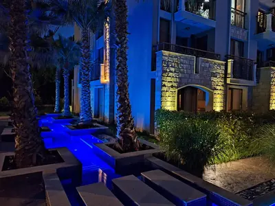 a building with palm trees and blue lights at 3 Room Apartment with Poolview in Cascadas Resort in Sunny Beach