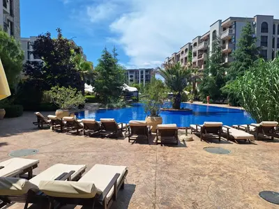 a resort with a pool with lounge chairs and tables at 3 Room Apartment with Poolview in Cascadas Resort in Sunny Beach