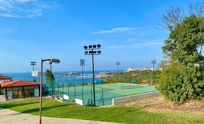 a tennis court in a park next to the water at AJ Apartment 3, Santa Marina Holiday Village, Sozopol in Sozopol