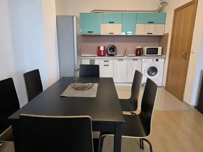 a black dining room table with chairs in a kitchen at Perla View Apartment in Primorsko