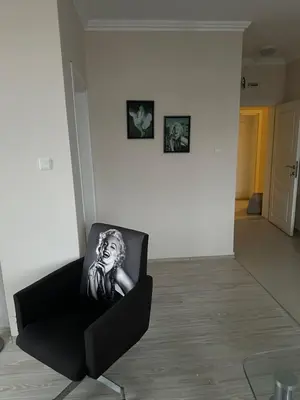 a black chair in a room with two pictures on the wall at 