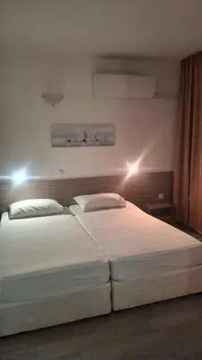 a bedroom with two beds with lights on the wall at Апартамент in Burgas City