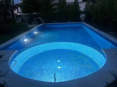 a large blue swimming pool at night at Villa LUNA in Kableshkovo