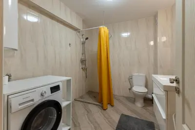 a washing machine in a bathroom with a toilet at Central 2BR - Workspace with Elevator in Varna City