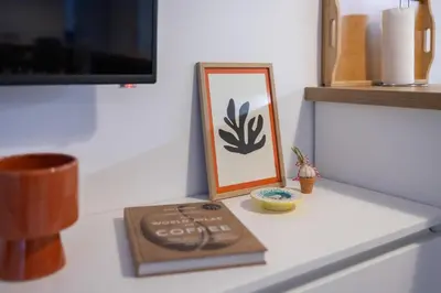 a table with a picture and a book on it at Central 2BR - Workspace with Elevator in Varna City