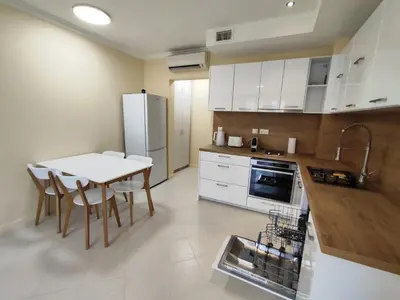 a kitchen with a white table and a white refrigerator at Santa Marina Breeze in Sozopol
