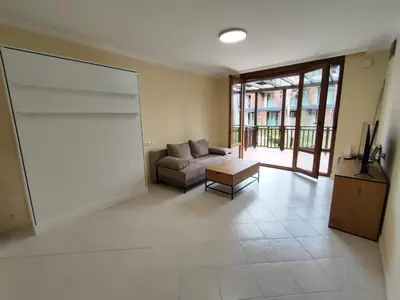 a large living room with a couch and a tv at Santa Marina Breeze in Sozopol