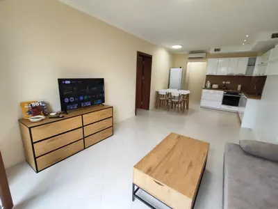 a living room with a couch and a television on a table at Santa Marina Breeze in Sozopol