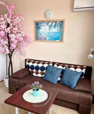 a living room with a brown couch and a table at Avrora Studio's in Byala