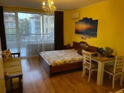 a bedroom with a bed and a table and a chair at Elegant Studio near Beach - Terrace & Parking in Nesebar
