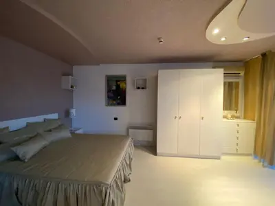 a bedroom with a bed and a white cabinet at Beautiful family appartment with sea view in Byala