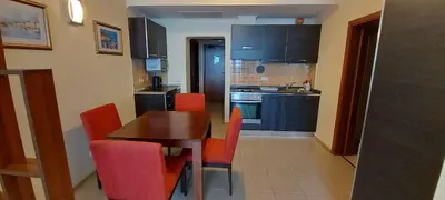 a kitchen with a wooden table and red chairs at Sunset C8-10 Pomorie in Pomorie