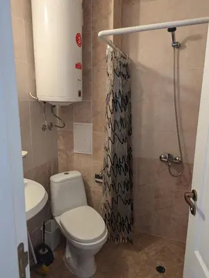 a bathroom with a toilet and a shower curtain at Sunny Day 5 in Tŭnkovo