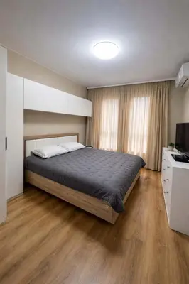 a bedroom with a large bed and a television at 1BD Apartment next to the Sea Garden by Flat Mаnager in Burgas City