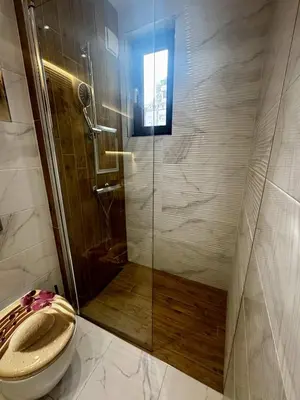 a bathroom with a toilet and a glass shower at 1BD Apartment next to the Sea Garden by Flat Mаnager in Burgas City