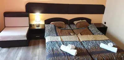a bedroom with a large bed with a black headboard at Морската Къща in Tsarevo