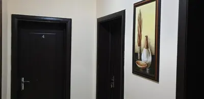 a hallway with two black doors and a picture at Морската Къща in Tsarevo