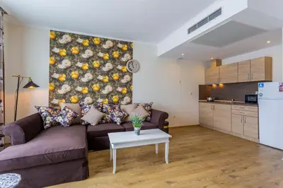 a living room with a couch and a table at Gardenia Beach Palace Aparthotel in Pomorie
