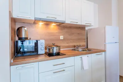 a kitchen with a microwave and a sink at Gardenia Beach Palace Aparthotel in Pomorie