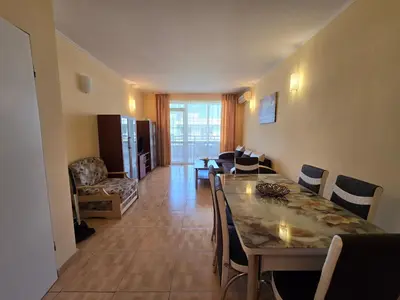 a dining room with a table and chairs and a living room at Apartment in Central Plaza in Sunny Beach