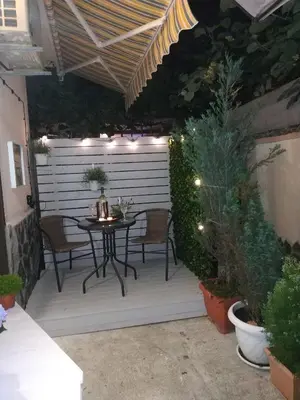 a patio with a table and chairs and lights at Rali Apartments in Kiten
