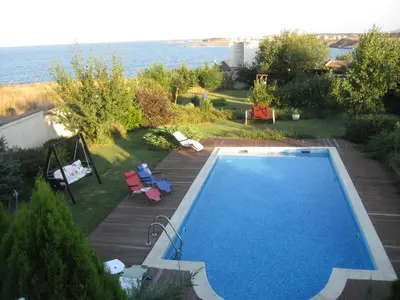 a swimming pool in a yard next to the water at Villa Magnet in Lozenets